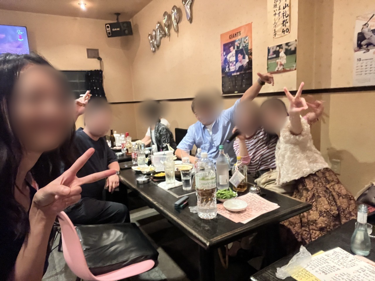 マイクを回しながらテーブルで盛り上がる常連さんたち