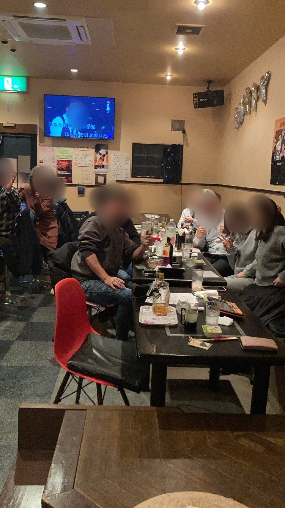 テーブル席でカラオケを聴きながら乾杯する常連さんたち